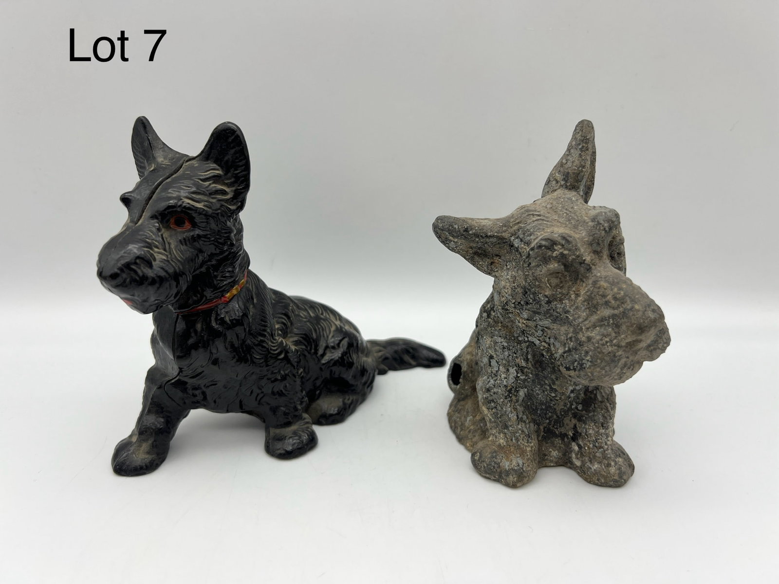 A Pair of Vintage Metal Scottish Terrier Still Banks: This is a pair of vintage metal Scottish Terrier still banks. The black cast metal bank is in very good condition and the spelter terrier has some damage. The black terrier measures 6"x4"x3".