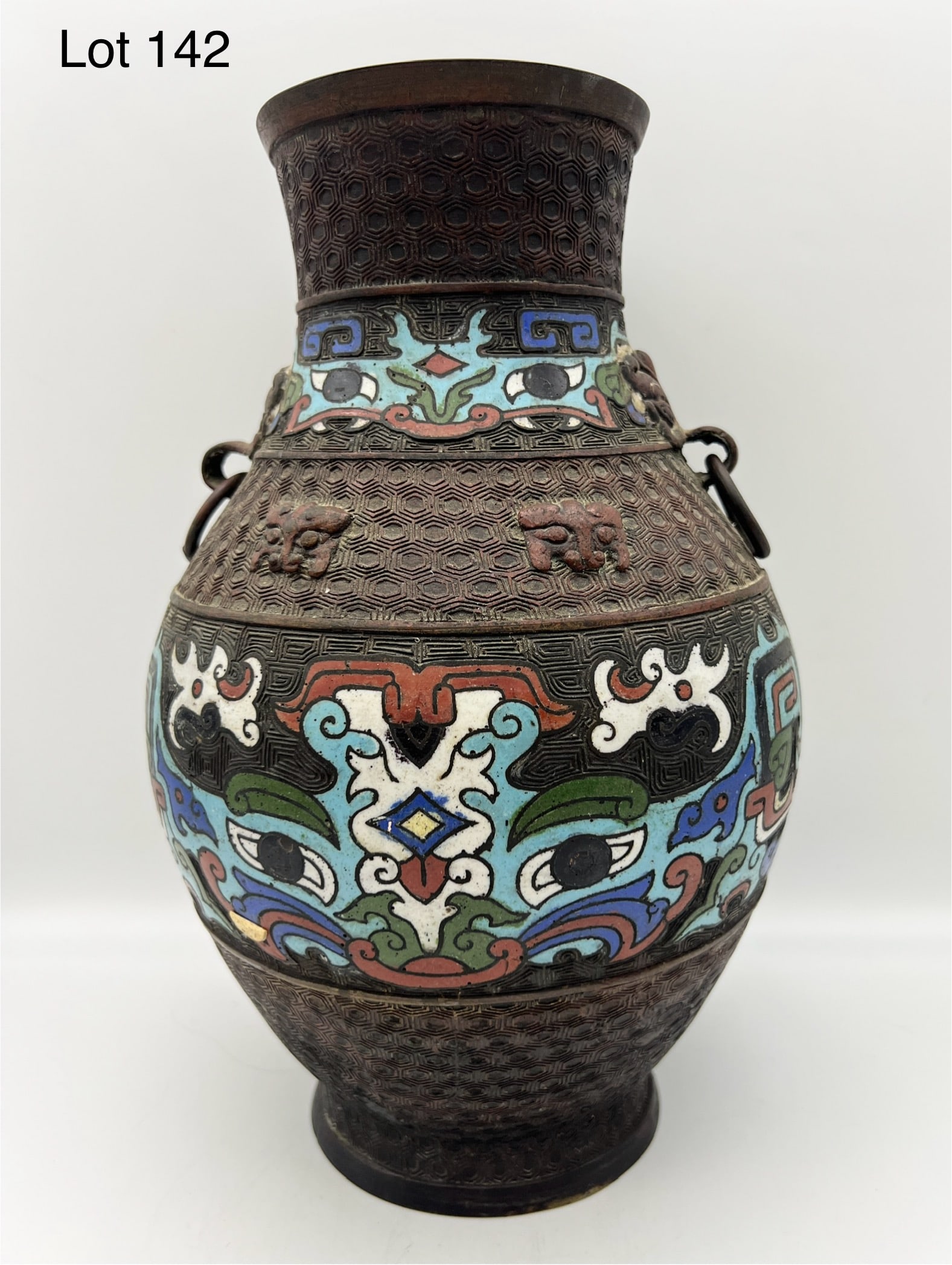 Japanese Meiji Bronze Champleve Cloisonne Enameled Vase: A 19th Century Japanese Meiji champleve and cloisonne bronze vase. This amphora shaped vase features colorful enamel decoration and dual ring handles. Stands 12" tall. *notes- patina