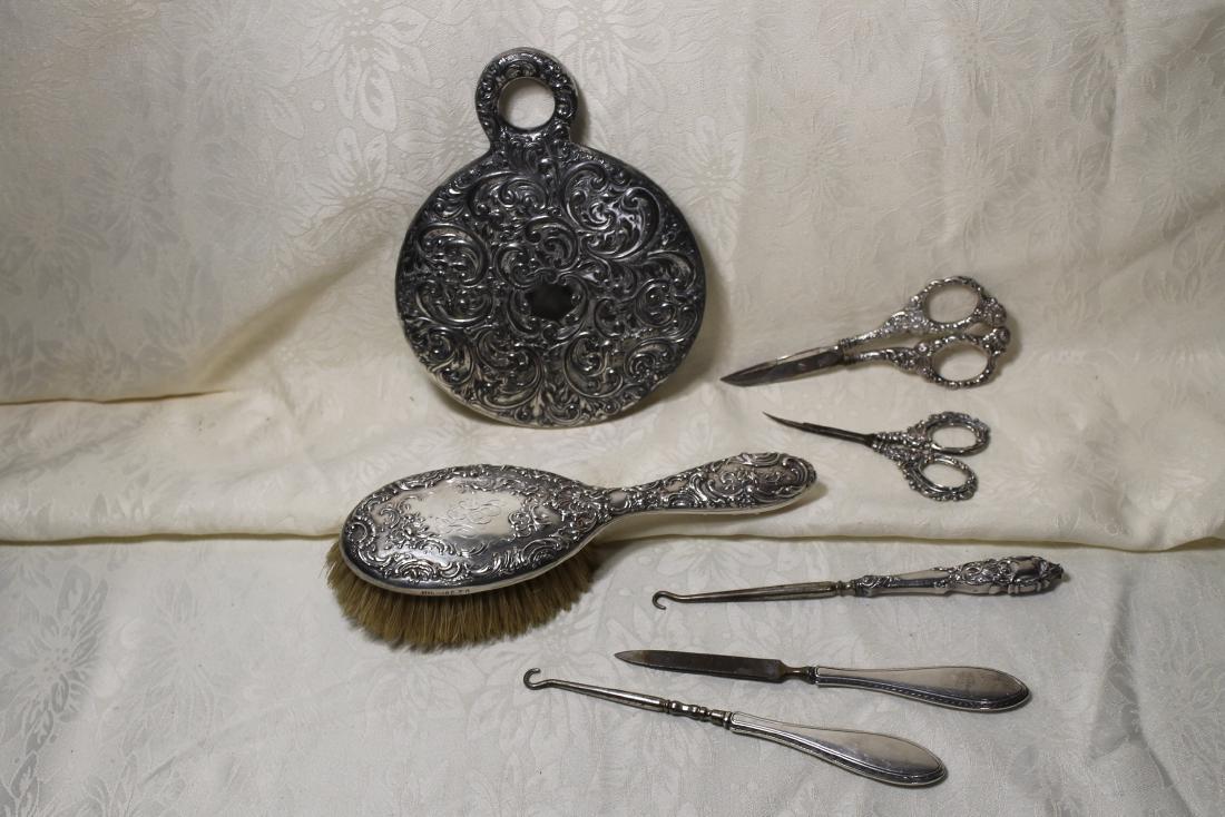 7 Pcs Sterling Handled Items: Assembled set of dresser items including 2 pair of scissors 4 1/2 x 5 3/4" 2 button hooks 1 file, 7" long, 1 brush 8" long, 1 hand mirror 7 3/4" all monogrammed.