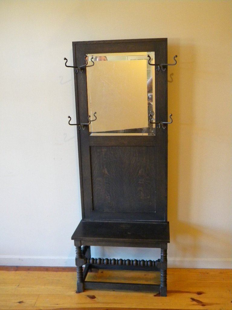 R.J. Horner, NY Jacobean Oak Hall Seat: Jacobean oak hall seat with 4 double hooks and beveled mirror, size is 6" tall by 26 1/2" wide and has an ivorine R.J. Horner label on reverse
