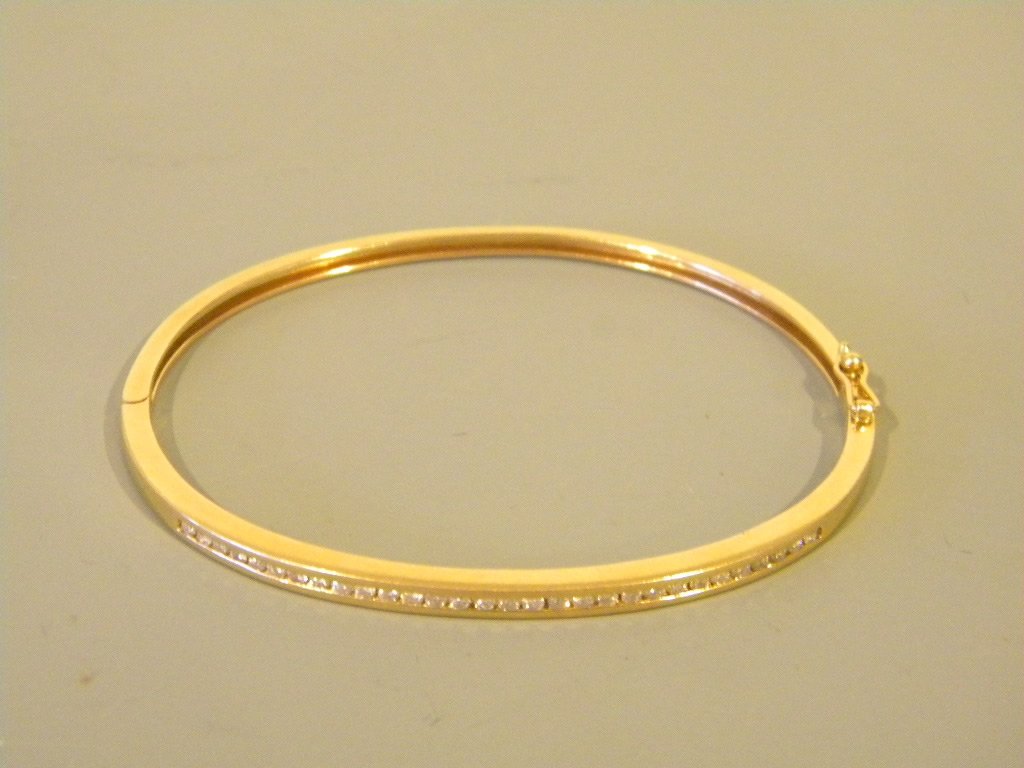 14 kt Gold & Diamond Cuff Bracelet: Channel set 14 kt gold and diamond bracelet. Set with .30 round cut diamonds. Weight is 11.2 grams and size is 6 1/2" in length.
