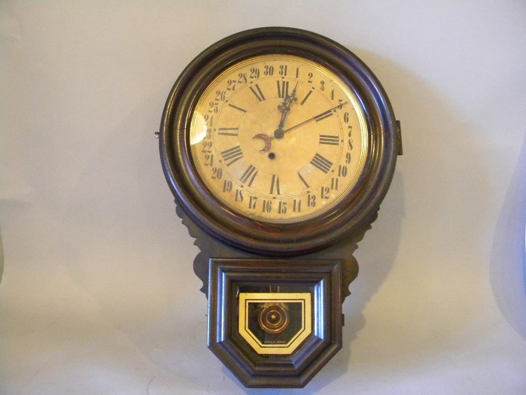 Ingraham Calendar Timepiece: Grain painted case with gold bordered glass advertising Boyle Bros. round Ingraham label to inside size is 24 1/2" x 16 1/2"