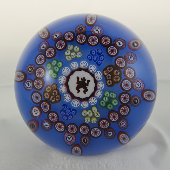 Baccarat, Modern 1977 Paperweight: Modern Baccarat 1977 paperweight. Cane 1, millifiori, gridel, devil. Devil Gridel. Red Devil in 8 pointed millifiori star design, gridel canes, on blue ground. DW: 79.5, HW: 59, W: 665.2