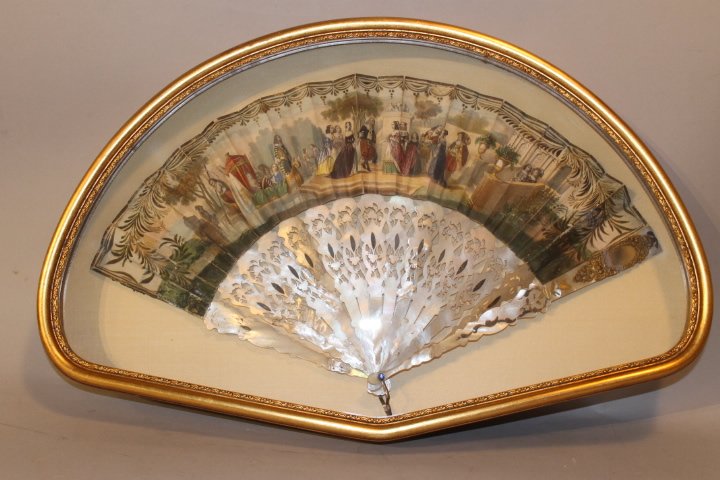 19th Century Framed Fan: Mother of pearl handled fan printed and painted Victorian scene, has applied mirror to one end. Overall size is 21 x 13" fan has some damage and repairs
