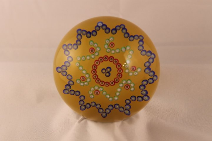 Baccarat, Modern 1991 Paperweight: Modern Baccarat 1991 paperweight. Cane 1, millifiori, patterned. Patterned Inca design millifiori on yellow - sun ground. Size is 3 1/4" wide by 2 1/4" tall. has box