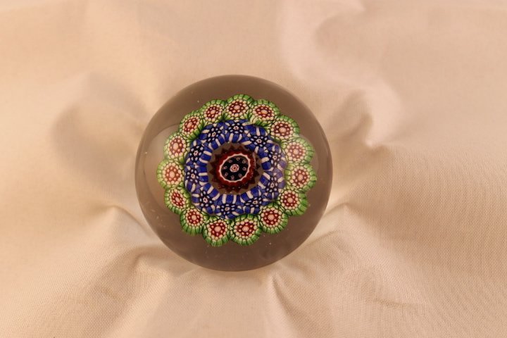 Baccarat, Antique Paperweight,undated: Cane 2, millifiori, concentric, miniature. Concentric millifiori, outer ring red, white and green star canes around pink bullseye; inner ring blue and white; red and white center cane, trefoil canes a