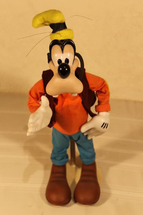 Disney Premier Edition Figure of Goofy: Disney Premier Edition Figure of Goofy. Disney character of Goofy with porcelain head, hands and feet. Appears to be a display piece. Some fading to orange turtleneck, dusty. LE 340/924. Marked Disney
