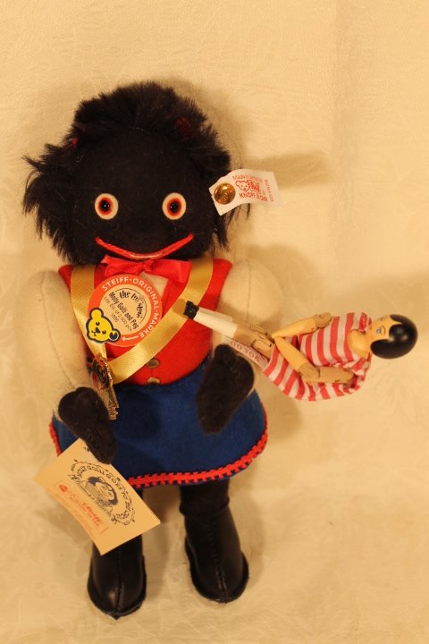 Molly Golli "Goes to The Circus" Steiff: Molly Golli "Goes to The Circus" Steiff. Molly Golli Goes to the Circus" Steiff doll with wooden doll in red stripes. Paper tags and white tag in ear. 9" tall