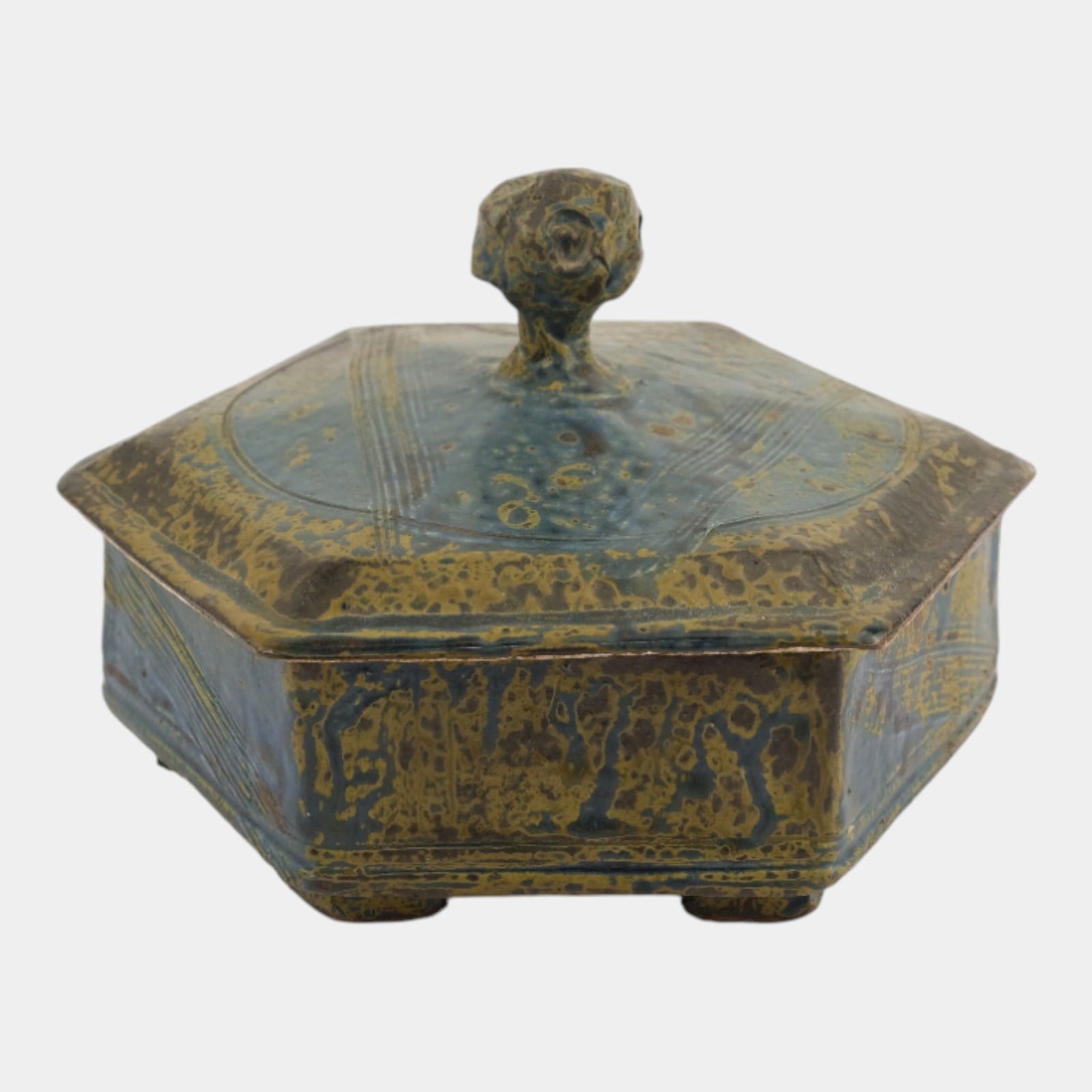 John Glick (1938-2017) Plum Tree Pottery Mottled Blue Hexagonal Lidded Jar: John Glick (1938-2017) Plum Tree Pottery Mottled Blue Hexagonal Lidded Jar Hexagonal lidded box by John Glick featuring a sculpted finial and layered glaze in mottled blue and ochre tones. The
