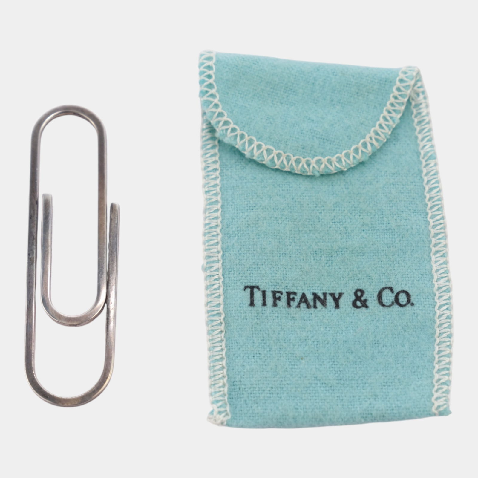 Tiffany & Co. Vintage Sterling Silver Minimalist Paper Clip Money Clip & Pouch: Sleek Tiffany & Co. sterling silver money clip featuring a clean, minimalist design and polished finish. Offered with the original Tiffany blue pouch, this refined accessory reflects the brandâ€