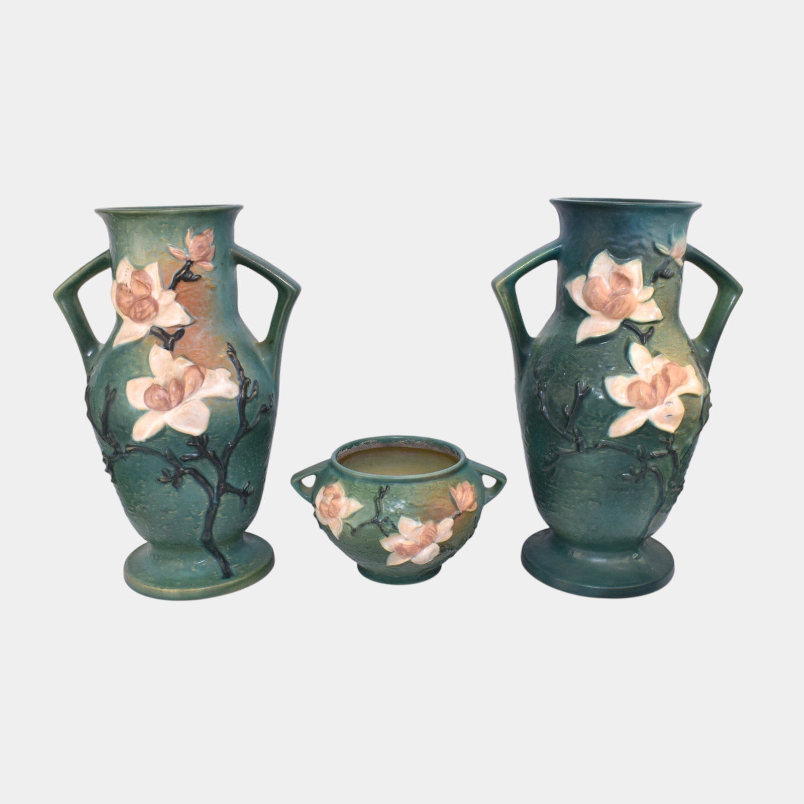 Roseville Magnolia Green Vases Jardiniere: We offer affordable in-house shipping on all items. Roseville Magnolia Green Vases Jardiniere One vase has chip to rim and body. Other vase has repair to rim. Vases are 15 3/4" tall and 10 1/2" wide.