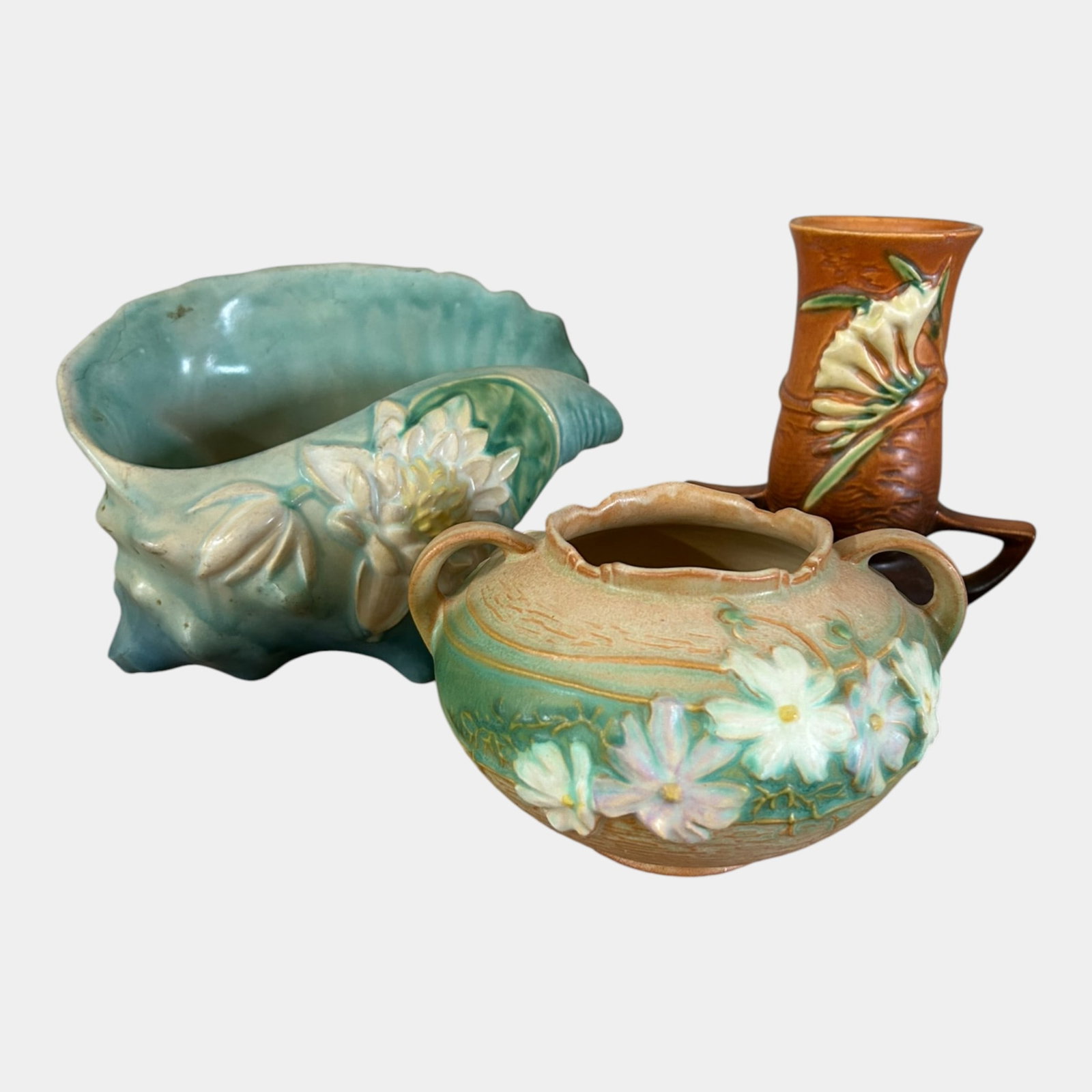 Roseville Art Pottery Mid Century Water Lily, Cosmos, & Freesia Vases And Shell Planter: We offer affordable in-house shipping on all items.For higher resolution images please visit bid.craftedauctions.com Roseville Art Pottery Mid Century Water Lily, Cosmos, & Freesia Vases And Shell Pla