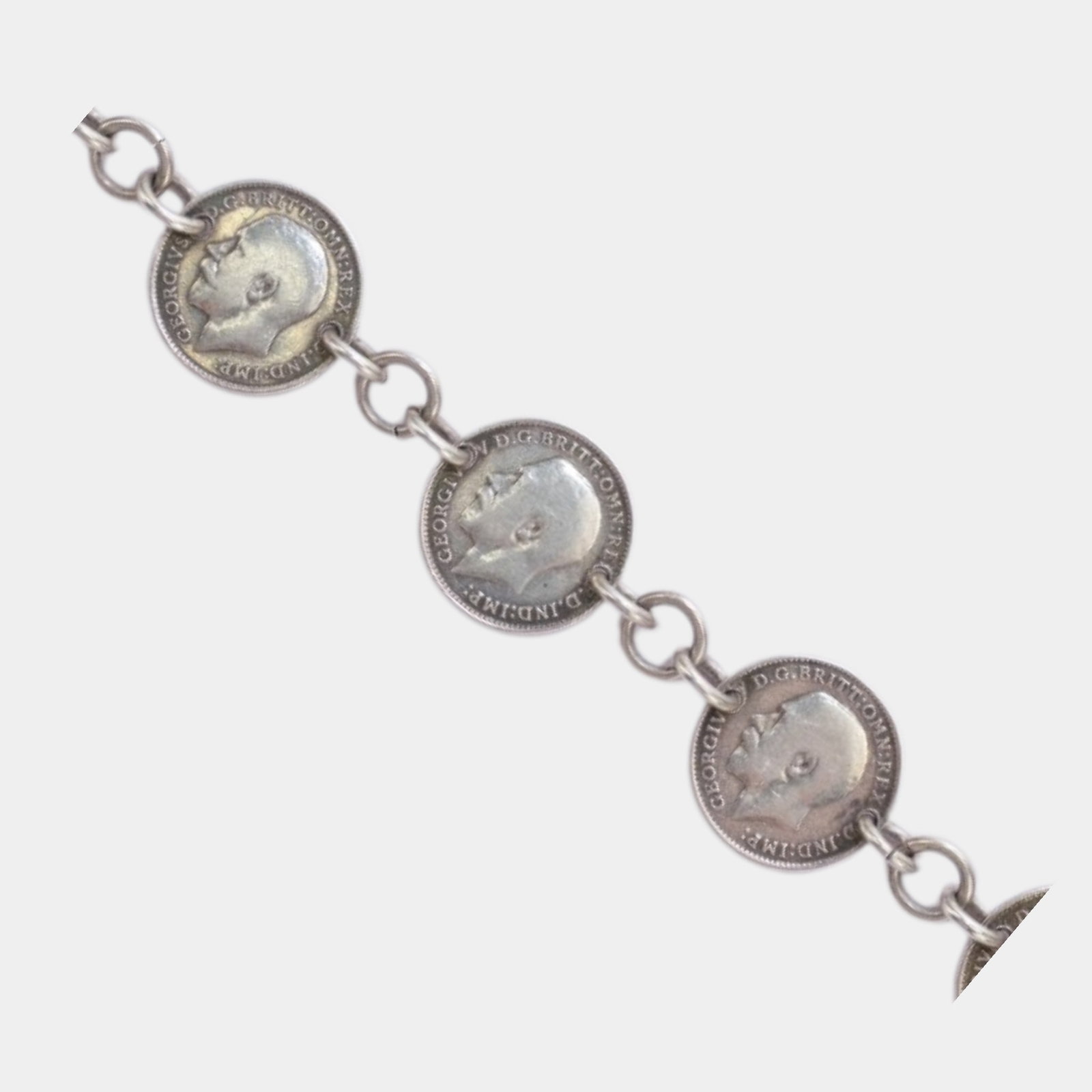 English 1913 Silver Three Pence Coin Linked 12K White Gold Filled Bracelet: We offer affordable in-house shipping on all items.For higher resolution images please visit bid.craftedauctions.com Charmingly nostalgic and finely detailed, this 12K gold filled bracelet features au
