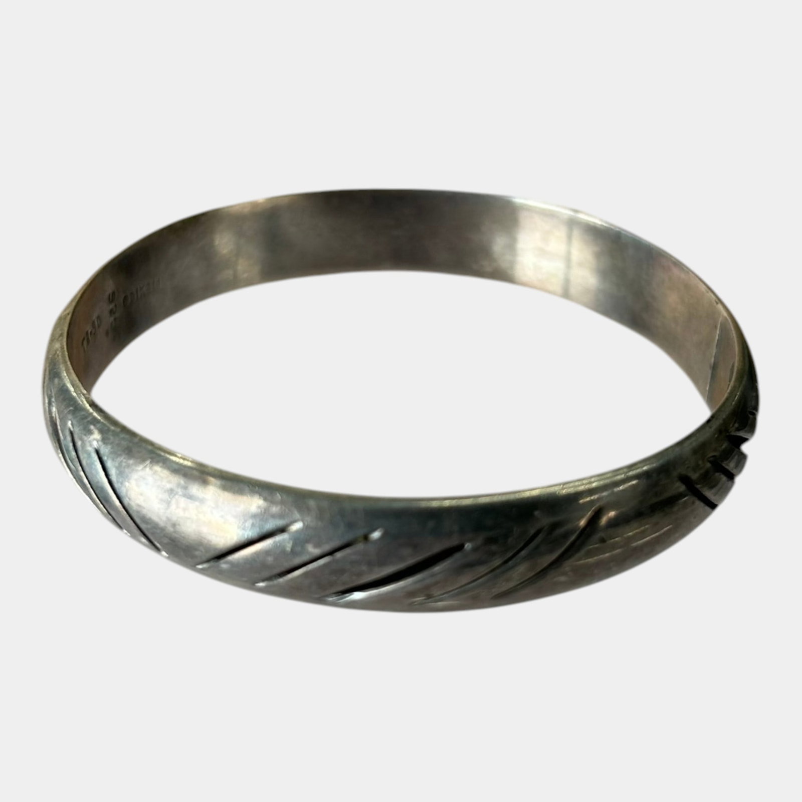 Feodoro Bueno For Taxco Mexico Mid Century Modernist Carved Line Design Closed Cuff Bangle: Professional, fast, and affordable in house shipping available for all items.For higher resolution images please visit www.bid.craftedauctions.com Boldly sculpted sterling silver cuff bracelet by Feod