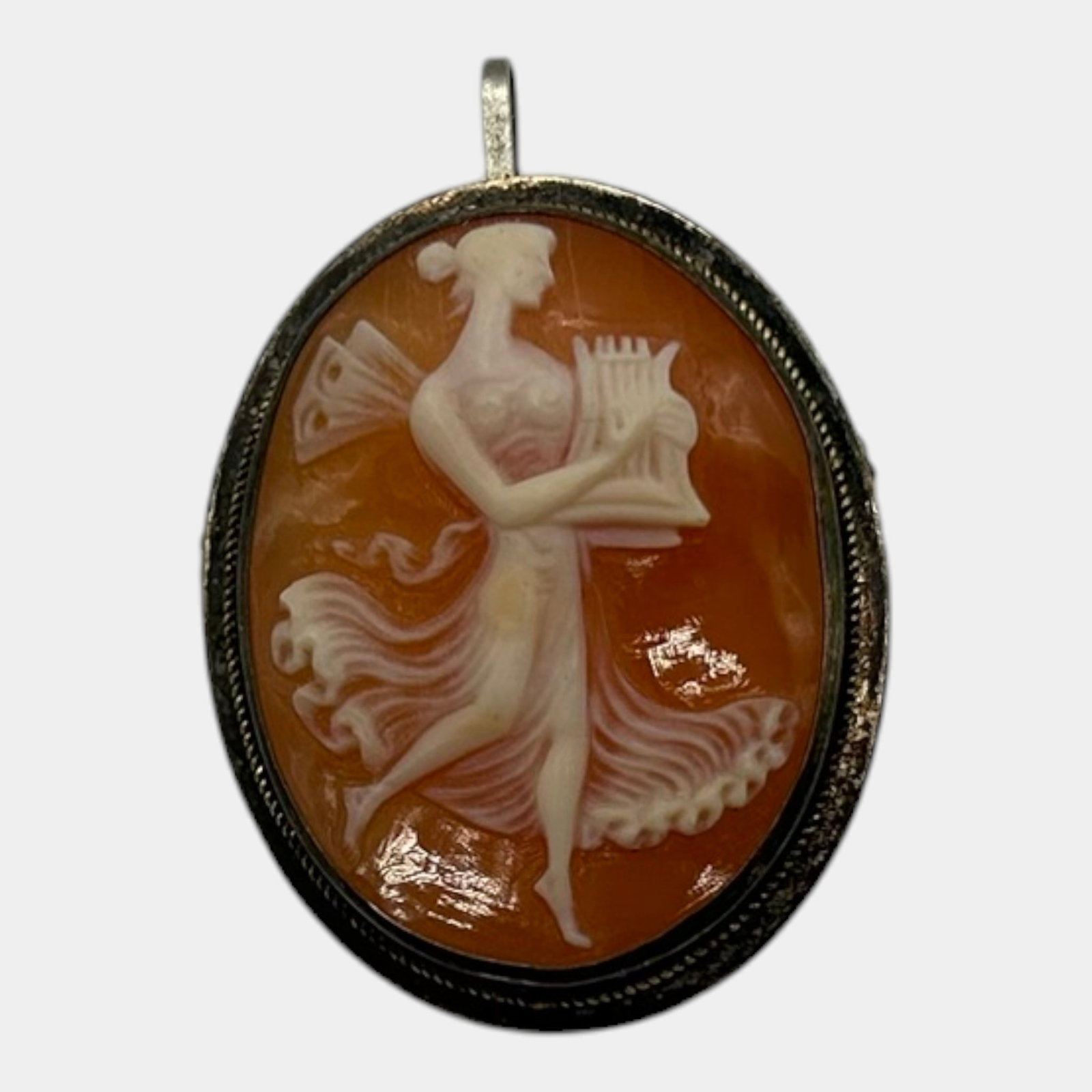 Sterling Silver 925 Carved Shell Cameo Pendant Depicting Muse With Lyre In Oval Frame: Professional, fast, and affordable in house shipping available for all items.For higher resolution images please visit www.bid.craftedauctions.com Elegant sterling silver cameo pendant featuring a fin