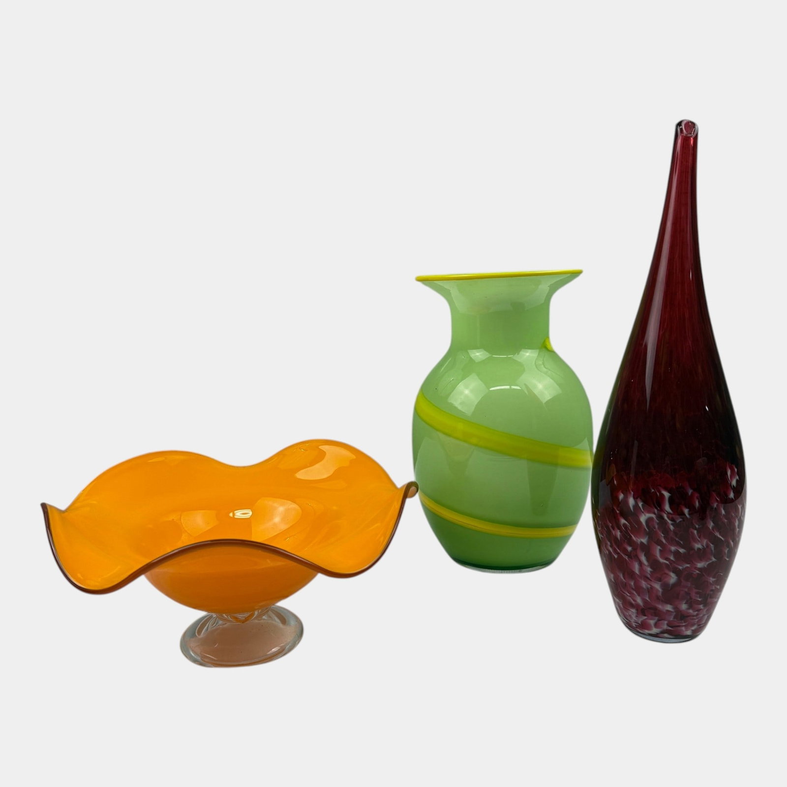 Art Glass Orange Pedestal Bowl Green Cased Vase & Cranberry Speckled Bottle Three Piece Lot: Professional, fast, and affordable in house shipping available for all items.For higher resolution images please visit bid.craftedauctions.com Art Glass Orange Pedestal Bowl Green Cased Vase & Cranber