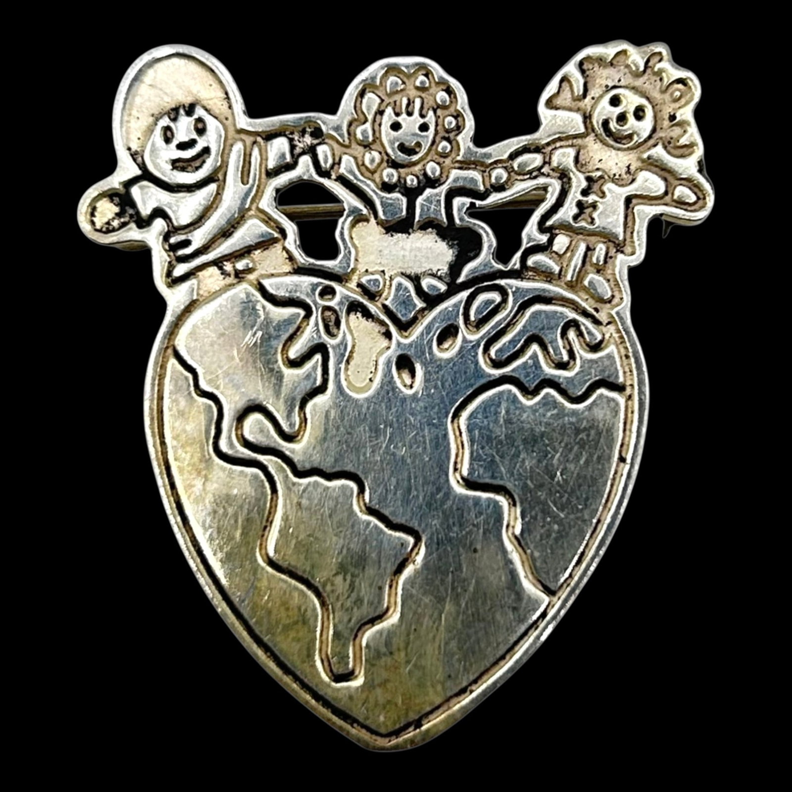 Mexico Sterling Silver "Save The Children" Heart World Brooch With Smiling Kids Figural Design: Professional, fast, and affordable in house shipping available for all items.For higher resolution images please visit bid.craftedauctions.com Whimsically designed, this Mexico sterling silver brooch 