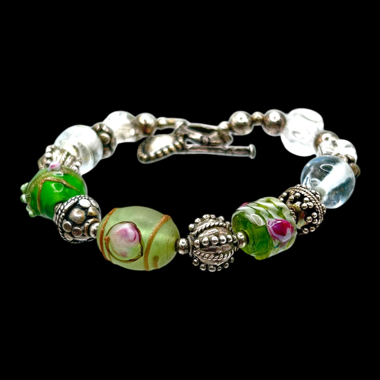 Sterling Silver Lampwork Art Glass Bead Charm Bracelet Green Floral & Blue Glass Designs: Professional, fast, and affordable in house shipping available for all items.For higher resolution images please visit bid.craftedauctions.com Colorfully handcrafted, this sterling silver bracelet fea