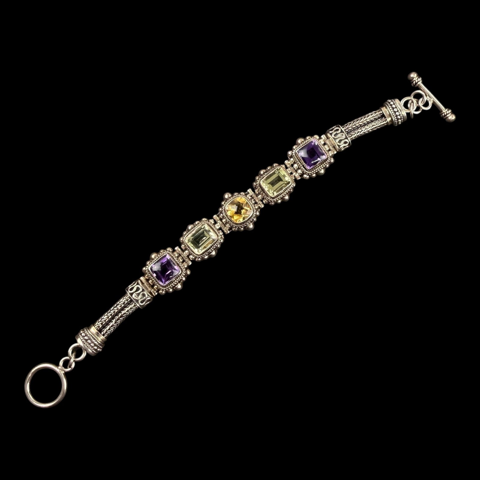 Desak Suarti Sterling Silver Multi Gemstone Bracelet With Citrine Peridot & Amethyst Gems: Professional, fast, and affordable in house shipping available for all items.For higher resolution images please visit bid.craftedauctions.com Desak Suarti Sterling Silver Multi Gemstone Bracelet With