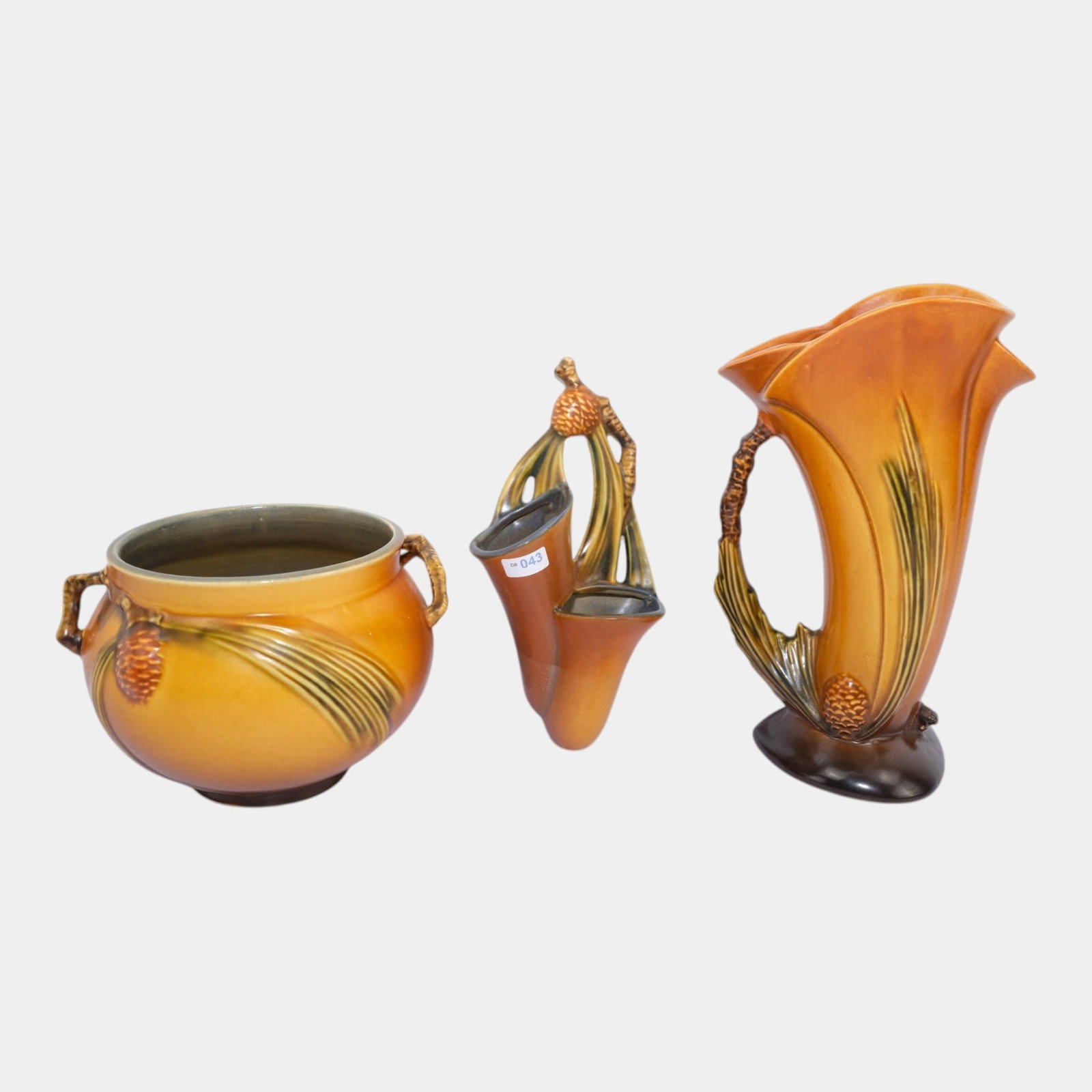 Roseville Art Pottery Pine Cone Brown Wall Pocket, Vase, & Pitcher: Professional, fast, and affordable in house shipping available for all items. For higher resolution images please visit bid.craftedauctions.com Roseville Art Pottery Pine Cone Brown Wall Pocket, Vase,