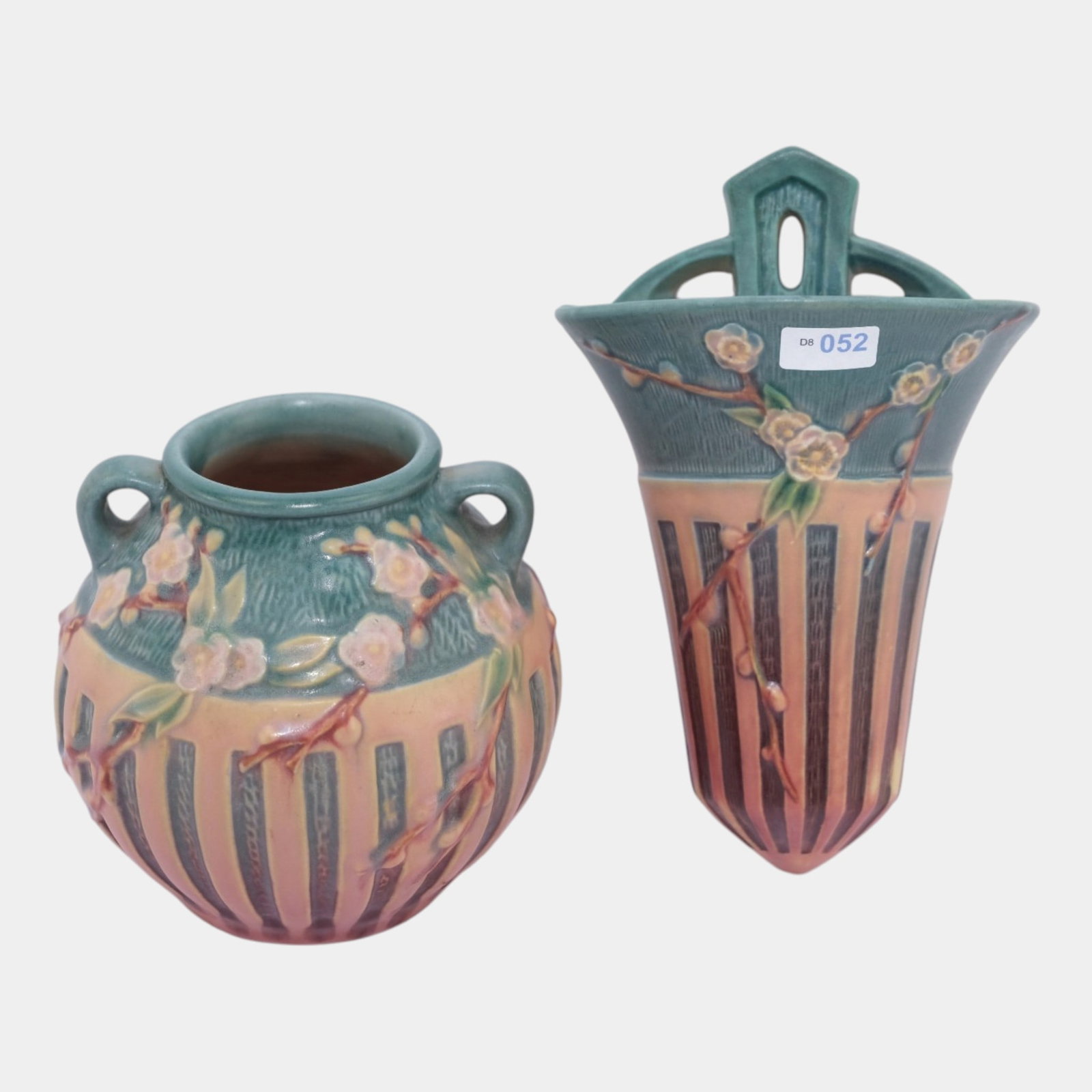 Roseville Cherry Blossom Pink 1933 Art Pottery Wall Pocket And Double Handled Vase: Professional, fast, and affordable in house shipping available for all items. For higher resolution images please visit bid.craftedauctions.com Roseville Cherry Blossom Pink 1933 Art Pottery Wall Pock