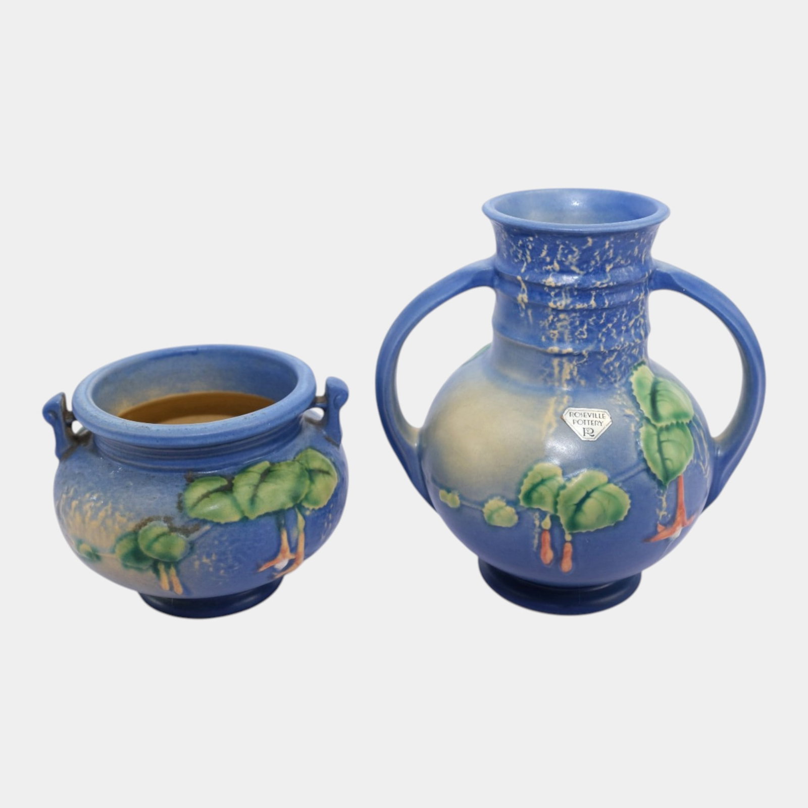 Roseville Fuschia Blue Art Pottery Handled Jardiniere And Looped Vase: Professional, fast, and affordable in house shipping available for all items. For higher resolution images please visit bid.craftedauctions.com Roseville Fuschia Blue Art Pottery Handled Jardiniere An
