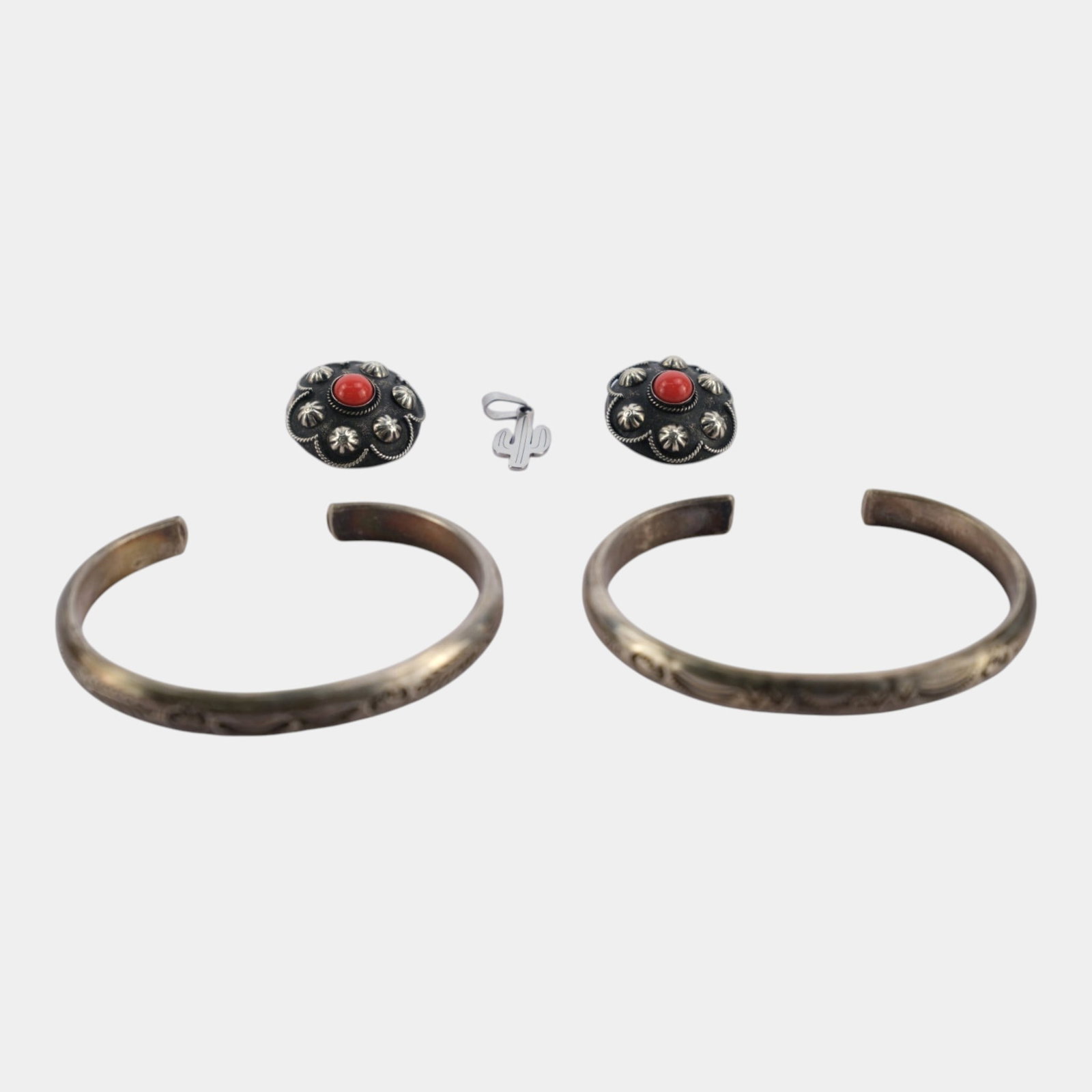 Southwestern Style Silver Tone Cuff Bracelets, Floral Clip Earrings, & Cactus Pendant Jewelry Group: Professional, fast, and affordable in house shipping available for all items. For higher resolution images please visit bid.craftedauctions.com Excellent condition. Age related wear. Marked as shown. 
