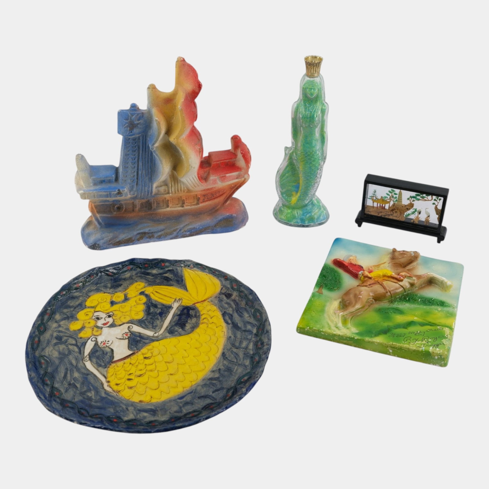 Vintage Chalkware Ship & Roy Rogers Tile, Mermaid Glass Bottle, & Pottery Mermaid Wall Plaque Group: Professional, fast, and affordable in house shipping available for all items. For higher resolution images please visit bid.craftedauctions.com Vintage Chalkware Ship & Roy Rogers Tile, Mermaid Glass 