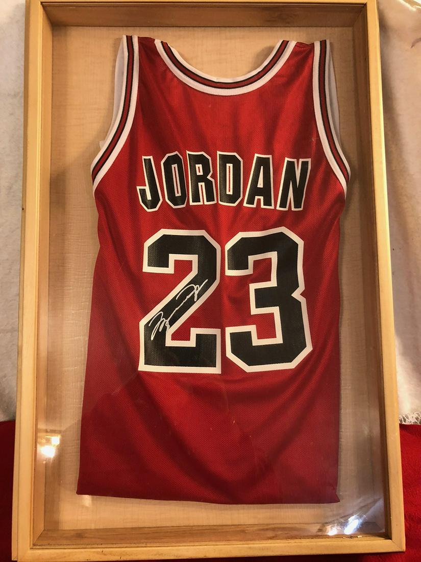 Michael Jordan Autographed Jersey: Michael Jordan autographed jersey in framed shadow box under glass. Measures approx. 32.5” tall x 22.25” wide.