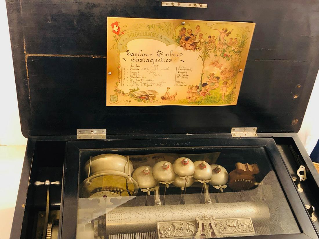 Swiss Music Box: Antique Swiss music box with marquetry inlay instruments and sheet music, bumble bee strikes and bells, original label, 8 Airs Program 12 Pouces. TamourTimbres Castagnetta with songs listed, with Jaco