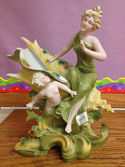 Statue Attributed to Royal Dux - Lady and Mermaid with : Attributed to Royal Dux Statue of Lady and Small Mermaid with Sea Shell. Pearlescent glazing inside of shell. Fingers missing on lady's hand and small chip on edge of shell.