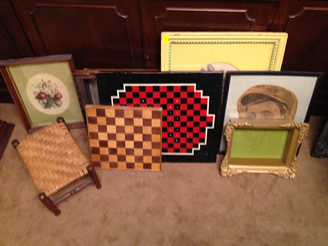 8 Piece Estate Lot: Estate Lot including 2 wooden game boards, one is very nice primitive red and black board, 2 shadow boxes, one is gold gilt, 2 flower prints with oval mattes, 1 small stool, and framed 1929 newspaper 