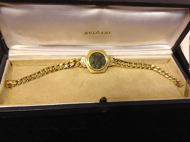 Bvlgari 18kt Gold Bracelet with Ancient Bronze Coin: Bvlgari 18kt Gold Bracelet with Ancient Bronze Coin. 18kt yellow gold bracelet with ancient bronze coin "Sicily Syracuse 310-304 B.C." total weight, approx. 62.0 grms. Has diamonds on both sides of co