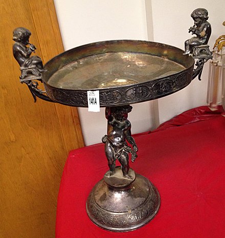 Antique Cherub Victorian Silver Plated Center Piece: Antique Cherub Victorian silver plated center piece with full cherub in center with grapes, cherubs on either end with flutes, cherubs depicted in different scenes around the edge. (marked Middletown 
