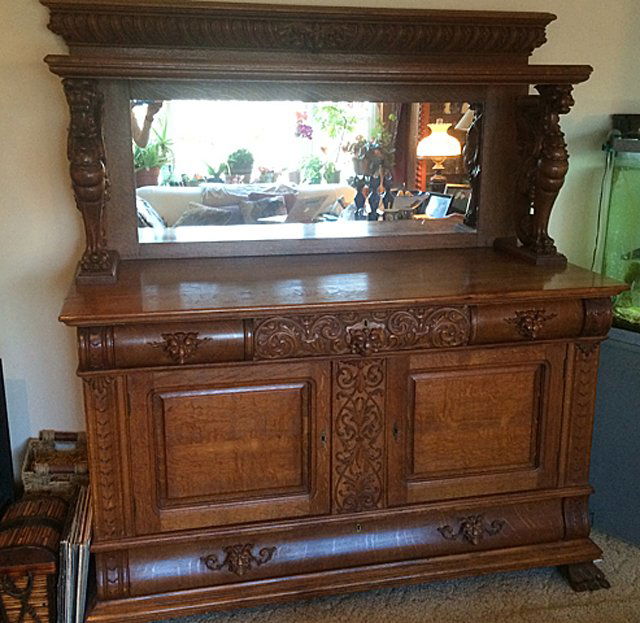 Oak Griffin Carved Side Board: Oak sidebaord with three short drawers across over 2 doors, over 1 long drawer. Top shelf with back splash and mirror held up on two sides by 3 dimensional fully carved Griffins. Griffins measure appr