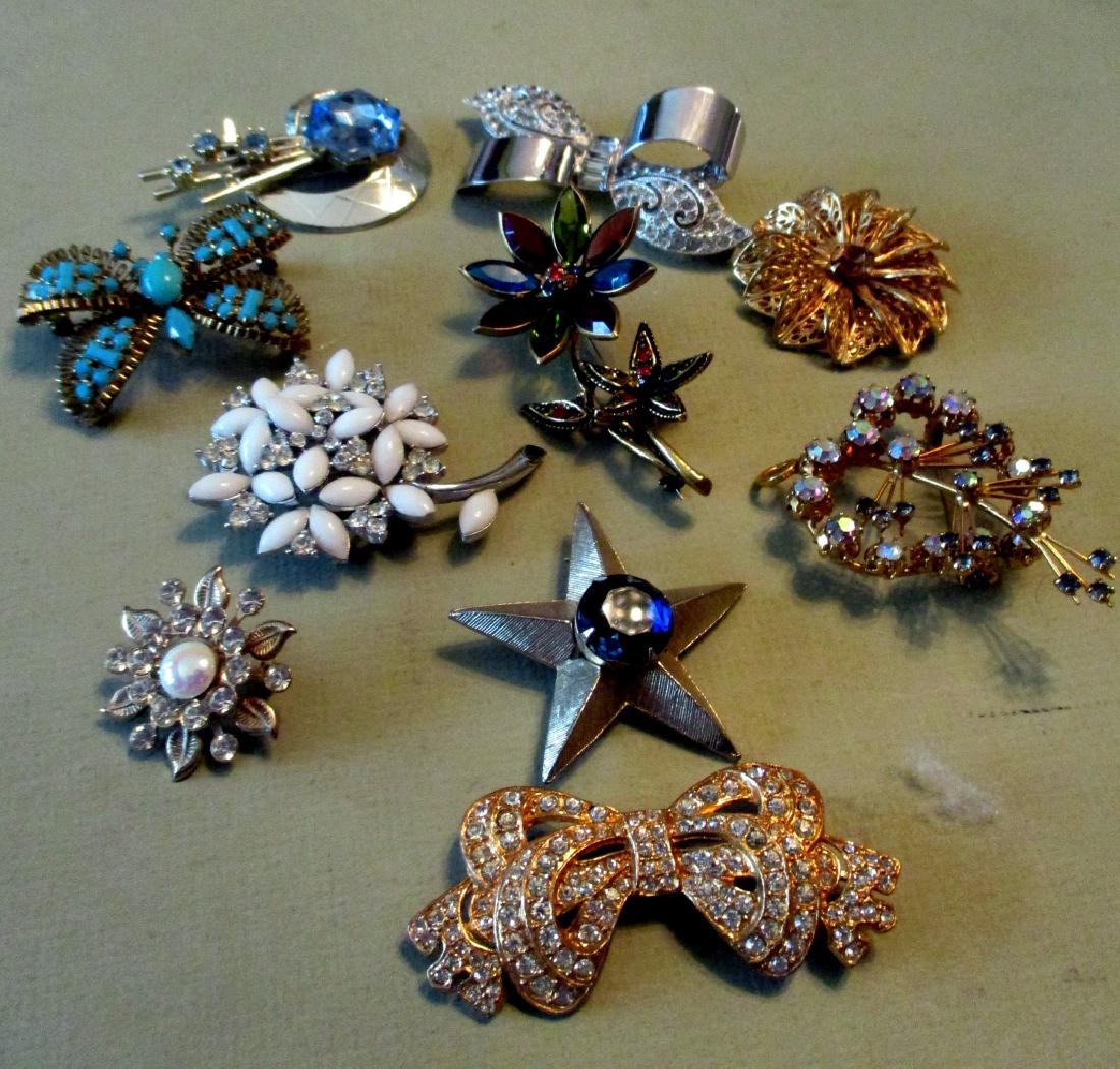 Ten Vintage Brooches: Lot consisting of 10 vintage brooches. Three are signed Trifari, Austria, and Mollycraft. All in good condition.