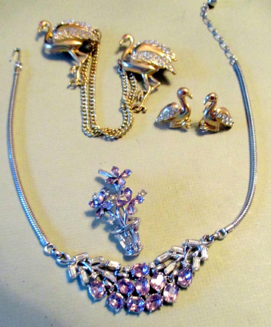 Two Sets of Vintage Costume Jewelry: Lot consisting of 2 flamingo motif brooches with matching earrings set with stones. One silver toned necklace with matching brooch set with faux amethyst stones. All in very good condition.