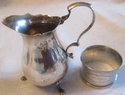 Two Piece Lot of Silver: Lot consists of English creamer with the hallmark C.A., 1899 and a sterling napkin ring engraved with a name. Both in good condition. Total weight is 2.49 OZT.