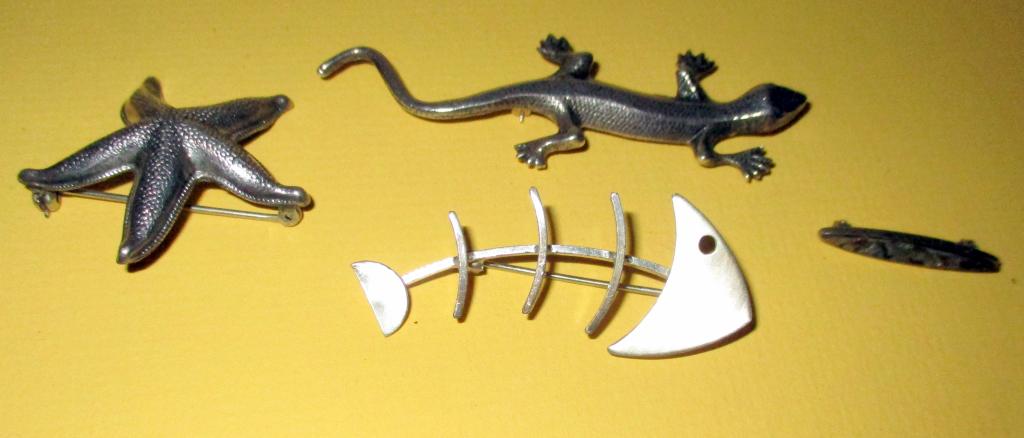 Lot of 4 Vintage Sterling Pins: Lot consists of a salamander motif sterling pin, a sterling pin of a fish skeleton by Jewelart, a sterling starfish pin and small abalone inlaid silver pin. All in good condition. Starfish is signed "
