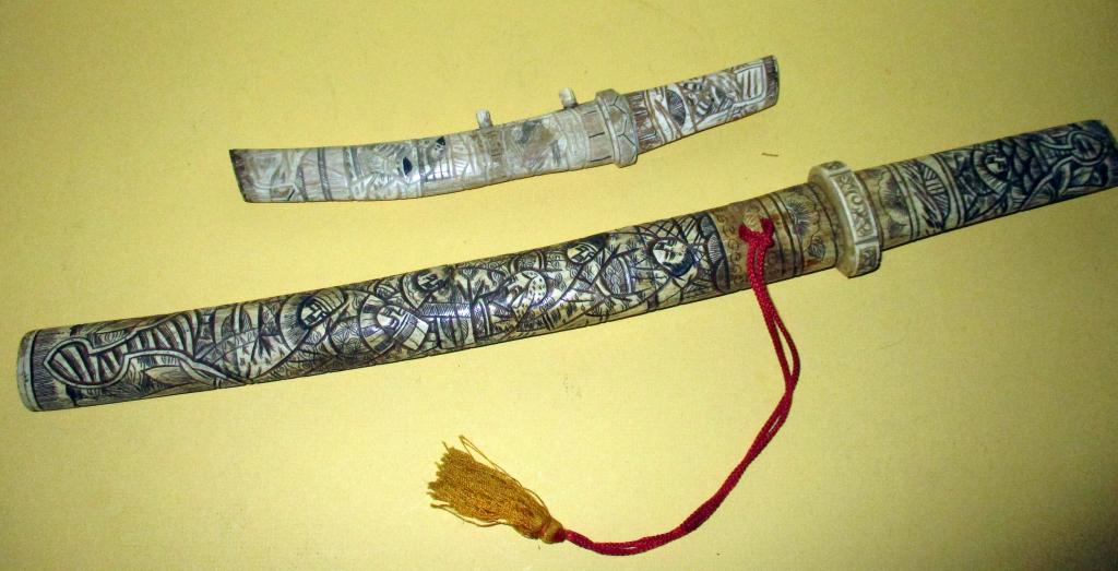 Two Japanese Daggers: Lot consists of a large Japanese dagger in a scrimshaw whale bone sheath and a small Japanese dagger in a scrimshaw whalebone sheath. Both are in fair to good condition. Approx. sizes are 21" and 11" 