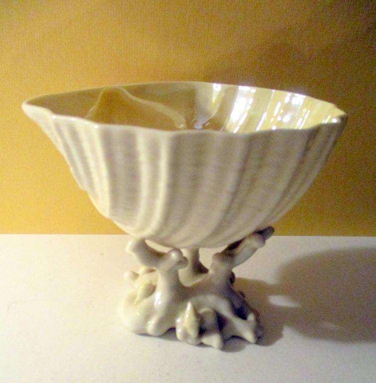Unusual Belleek Porcelain Compote: Unusual Belleek compote on a shell motif sitting on branches of coral. Stamped with a reddish brown Belleek mark. Approx. 5" inches tall and 6" inches across the top. In very good condition.