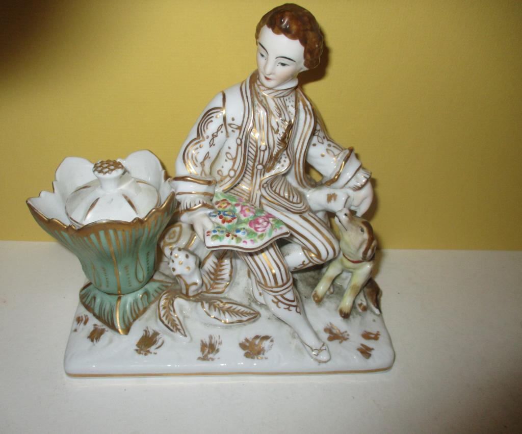 Paris ? Porcelain Ink Stand: Lot consists of Paris ? porcelain ink stand depicting a young man sitting down reading a letter with a small dog by his side. It has a porcelain ink liner. Approximate size is 7" inches tall by 8" inc
