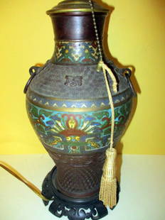 Japanese Champleve Lamp: Consists of a Bronze Japanese Urn with Champleve Decoration. Made into a Lamp on Carved Oriental Base. Approximate Height to the Top Finial is 25" inches. In Good Condition