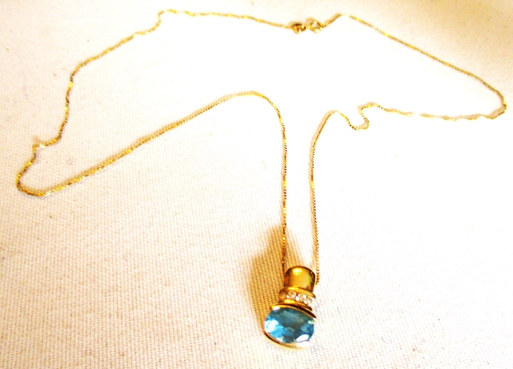 14K Gold Pendant with Blue Topaz & Chain: Lot Consists of a Blue Topaz Pendant Set in a 14K Gold with a Row of Diamonds Above on a 14K Gold Chain. Approximate Total Weight is 4.2 Grams. In Good Condition.