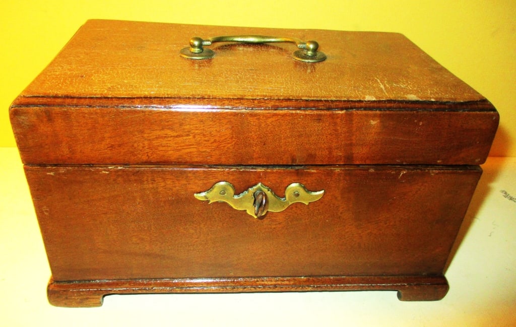 19th Century Georgian Tea Caddy: Lot Consists of a English Georgian Mahogany Tea Caddy. Unfortunately it is Missing 2 Interior Wooded Covers. Approximate Size is 5" Inches Tall, 8 1/2" Inches Long and 5" Inches Deep. Except for Missi
