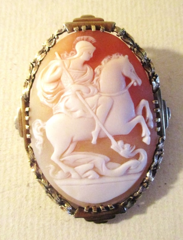 14K Gold Shell Cameo Brooch/Pendant: Lot Consists of a Beautiful Shell Carved Cameo of St. George Slaying a Serpent. It Set in a 14K Gold Setting. The Size is Approximate 2" Inches Long and Approximate Width is 1 1/2 Inches. The Approxim