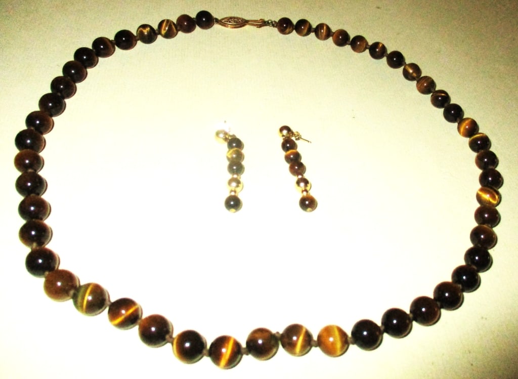 Lot Tiger Eye Bead Necklace and Earrings: Lot Consists of a Strand Neck Lace of Tiger Eye Beads, Also With a Pair of Tiger Eye Earrings. The Earrings Have A Gold Filled Bead in it. Size of Necklace is Approximately 21" Inches. In Good Conditi