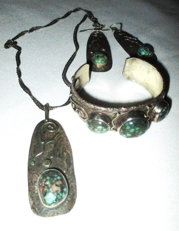 Set of Southwest Navajo Silver Jewelry with Stones: Lot Consists of a 4 Piece Set of Southwest Navajo Sterling Jewelry. The Set Has a Sterling Pendant on Chain, a Pair of Earrings and a Ring all Set with a Green Turquoise Stones. The Chain is Sterling 