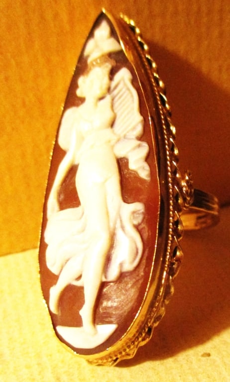 Lady's 10K Gold Ring Set With a Cameo: Lot Consists of a Tested 10K Gold Lady's Ring Set With a Shell Cameo of a Girl Dancing. Approximate Ring Size is 8. The Total Approximate Weight is 4.9 dwt. The Cameo is 2" Inches Long.