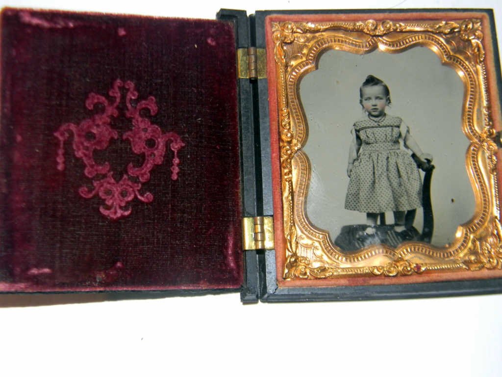 Daguerreotype/Ambrotype of Baby Standing on Chair: Daguerreotype / Ambrotype of baby standing on chair set in an unusual gutta-percha case. Motif on front and back is that of a lady riding a stallion side saddle. Case is missing three end pieces on on